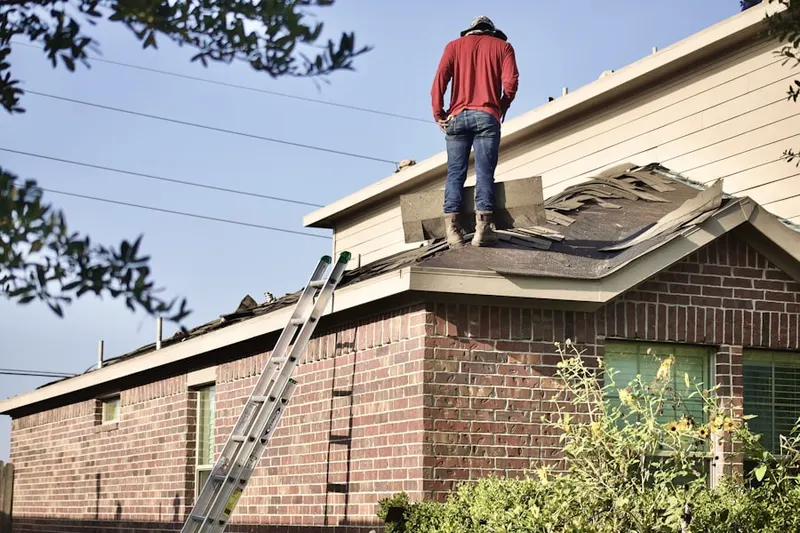 Professional roofer working on a residential roof in Warroad